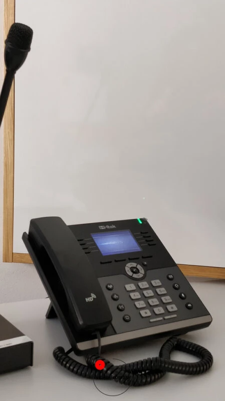Telefono VoIP professionale con microfono da conferenza su scrivania Telefono VoIP da tavolo con display e microfono a collo di cigno per comunicazioni in ambienti professionali